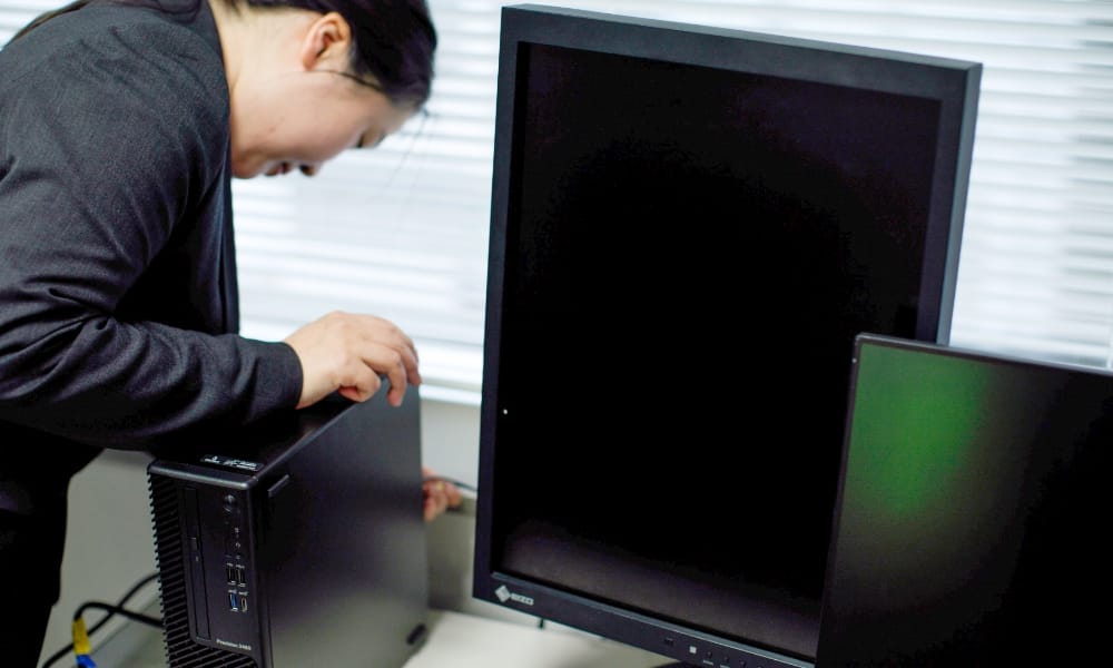 システム導入の業務風景（セットアップ完了後のPCを現地で設置作業）